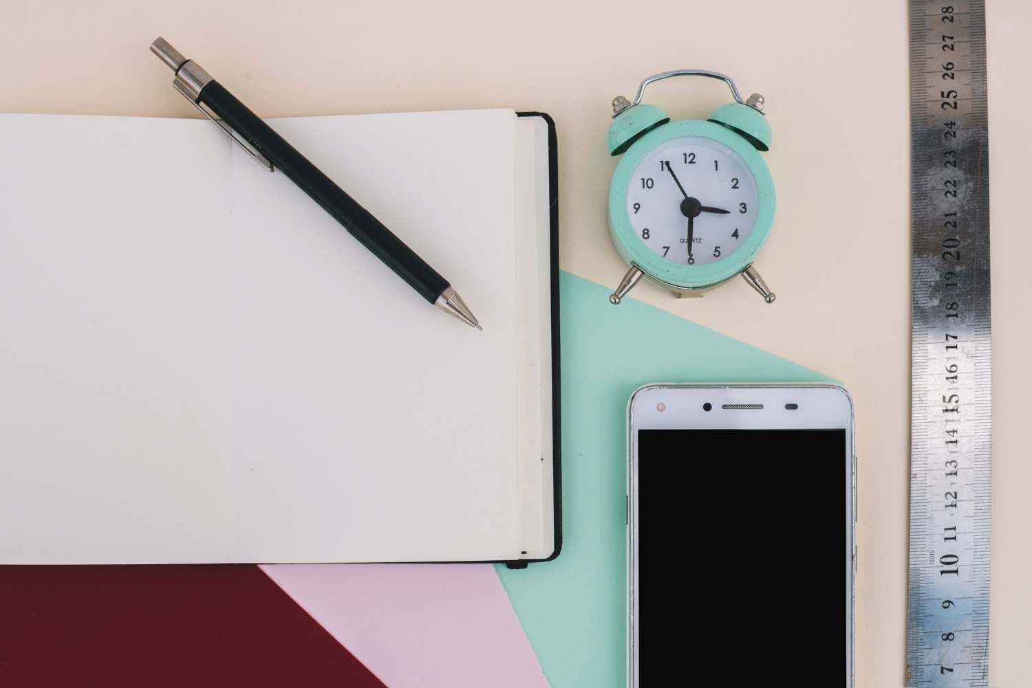 Mobile, pen, timer & notebook is on the table